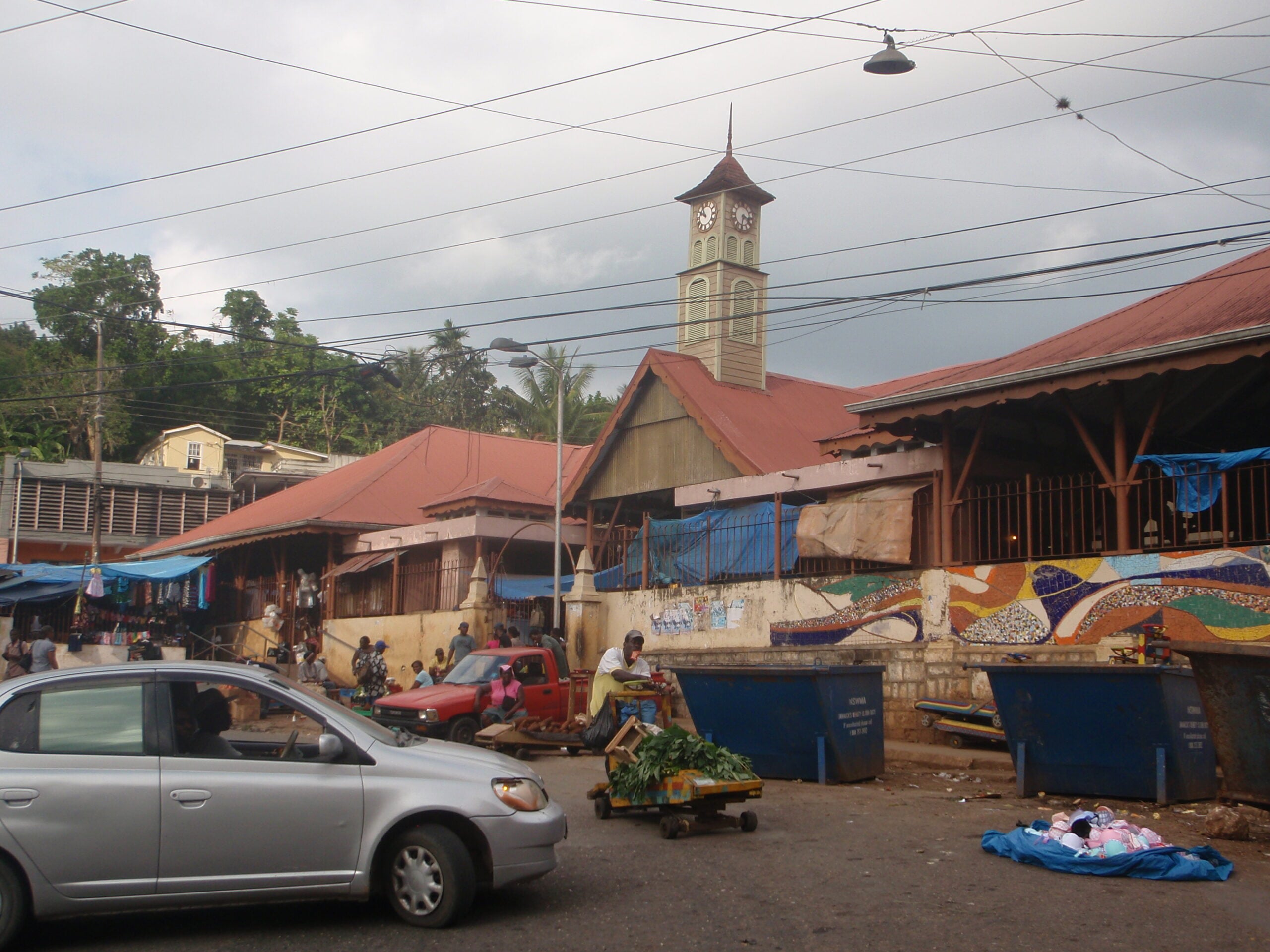 Brown’s Town market building and clock tower, with pedestrians, stalls and traffic in the foreground.